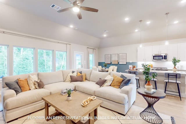 living room with ceiling fan, a healthy amount of sunlight, vaulted ceiling, and light hardwood / wood-style floors