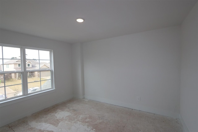 unfurnished room with baseboards