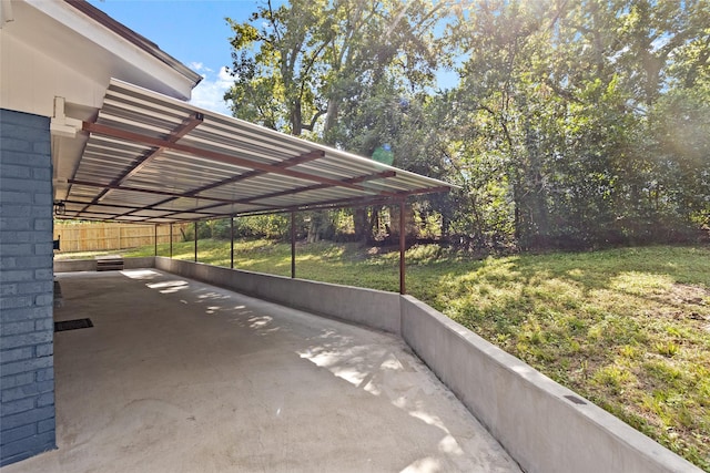 view of parking / parking lot with a carport and a lawn