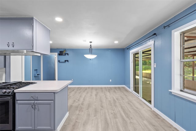 kitchen with light wood-type flooring, pendant lighting, gas stove, and plenty of natural light