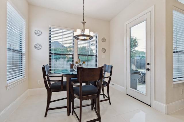 tiled dining area featuring a notable chandelier and a wealth of natural light