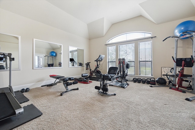 exercise area featuring vaulted ceiling and carpet flooring