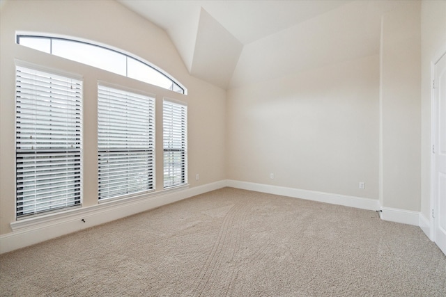 carpeted empty room with lofted ceiling