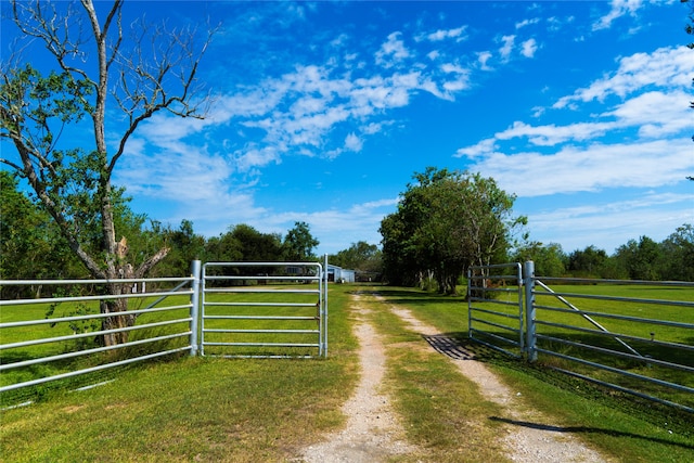 view of gate featuring a yard and a rural view