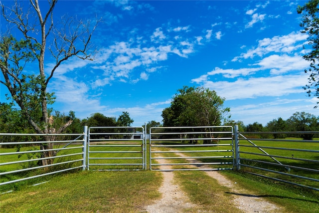 view of gate with a rural view and a yard