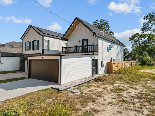 view of property exterior with a garage and a balcony