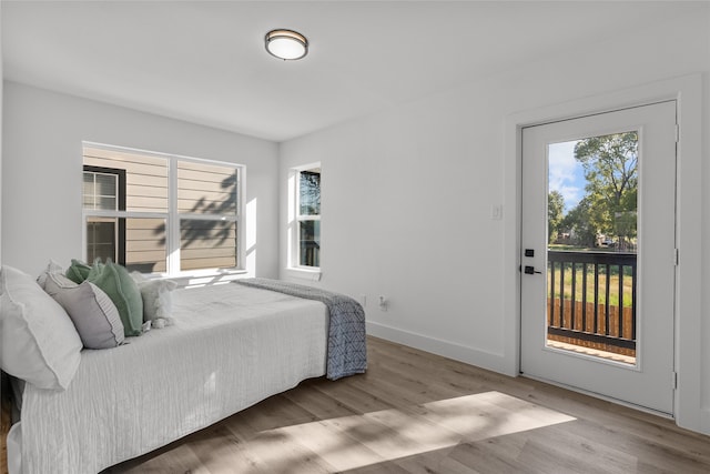 bedroom with hardwood / wood-style floors and access to exterior