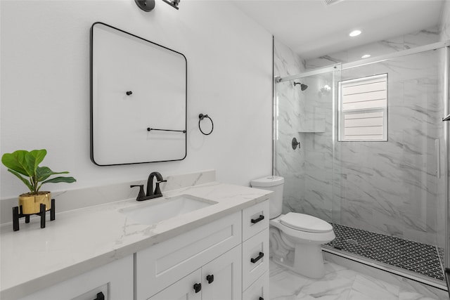 bathroom featuring toilet, vanity, and a shower with door