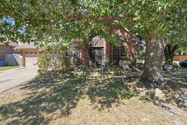 view of property hidden behind natural elements with a front lawn and a garage