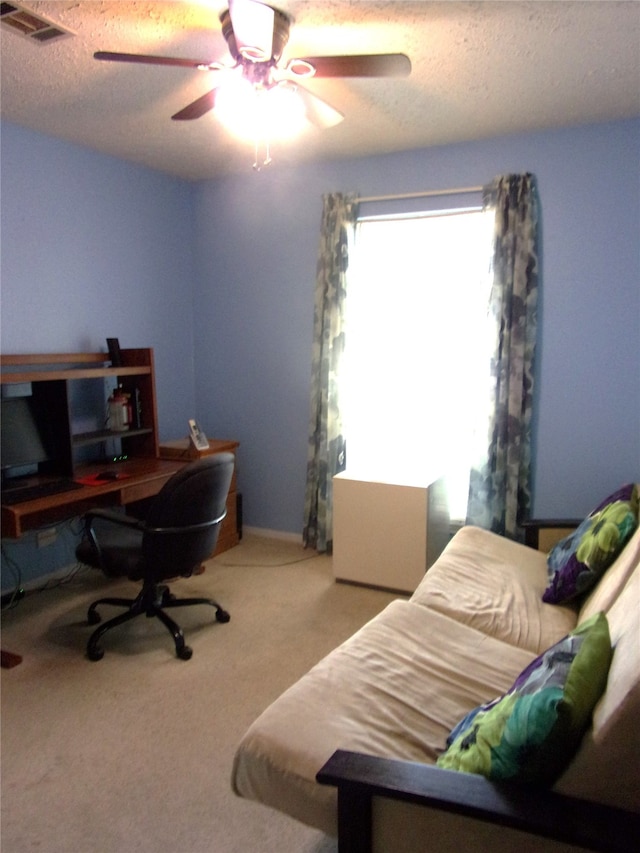 home office with carpet floors, a textured ceiling, and ceiling fan