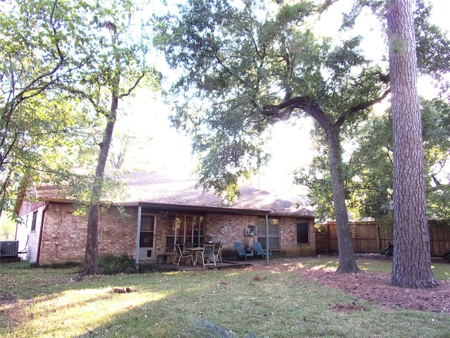 back of property with cooling unit and a lawn