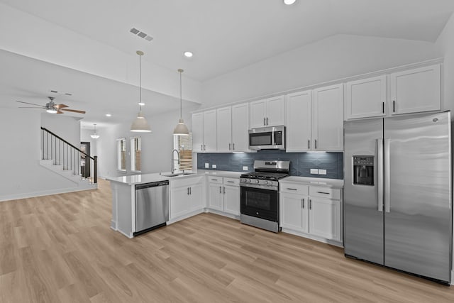 kitchen featuring a sink, stainless steel appliances, a peninsula, white cabinetry, and visible vents