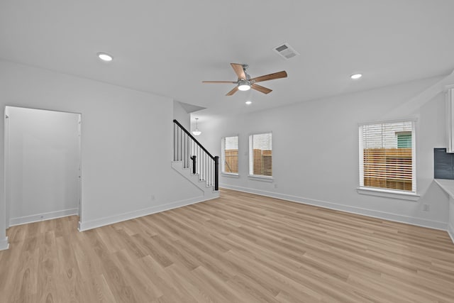 unfurnished living room featuring stairway, a ceiling fan, light wood finished floors, visible vents, and recessed lighting