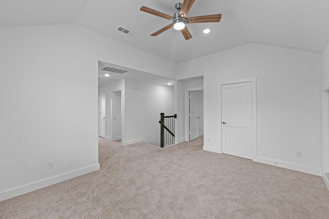 carpeted spare room with ceiling fan, lofted ceiling, visible vents, and baseboards