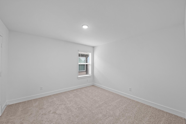 spare room with baseboards and carpet flooring
