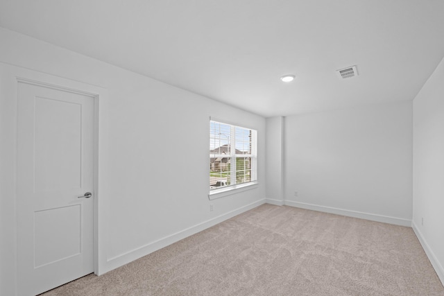 empty room featuring light carpet, baseboards, visible vents, and recessed lighting