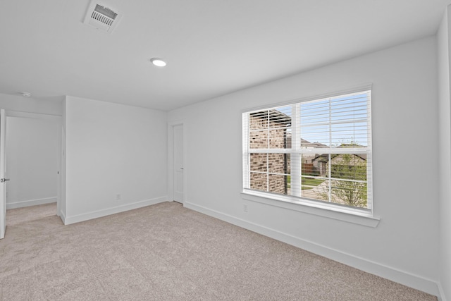 empty room featuring light carpet, baseboards, visible vents, and recessed lighting