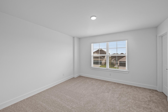 carpeted empty room with baseboards