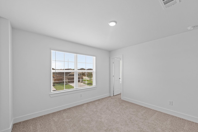 empty room featuring visible vents, carpet flooring, and baseboards