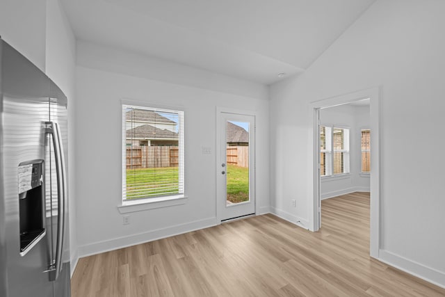 interior space featuring baseboards and light wood finished floors