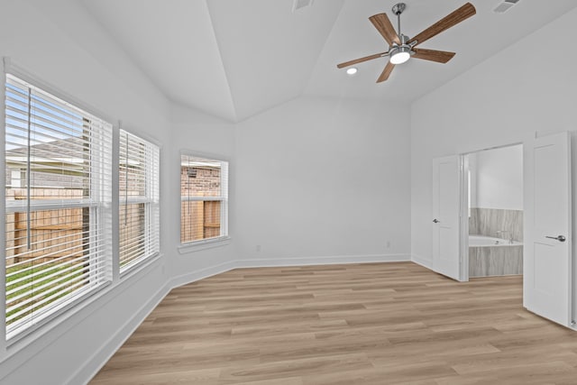 spare room with light wood-style flooring, visible vents, baseboards, a ceiling fan, and high vaulted ceiling
