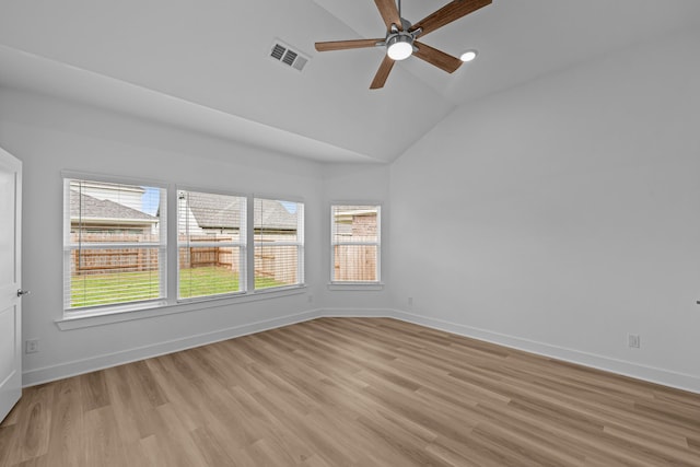 spare room with light wood-type flooring, baseboards, visible vents, lofted ceiling, and a ceiling fan