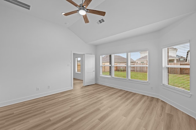empty room with a wealth of natural light, visible vents, and light wood-type flooring