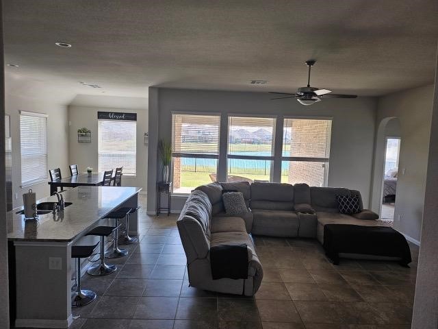 tiled living room featuring ceiling fan