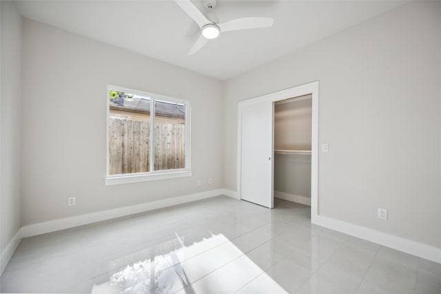 unfurnished bedroom with light tile patterned floors, ceiling fan, and a closet