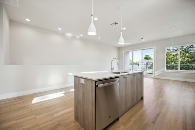 kitchen with pendant lighting, dishwasher, light hardwood / wood-style floors, a kitchen island with sink, and sink