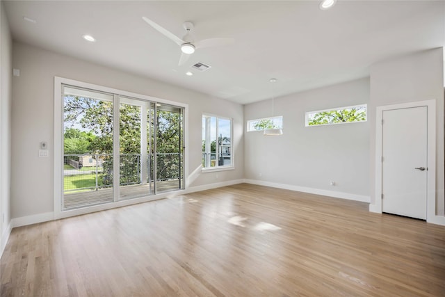 unfurnished room featuring a healthy amount of sunlight, light hardwood / wood-style floors, and ceiling fan