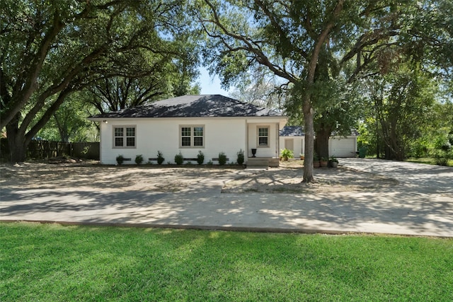 ranch-style home with a garage and a front lawn