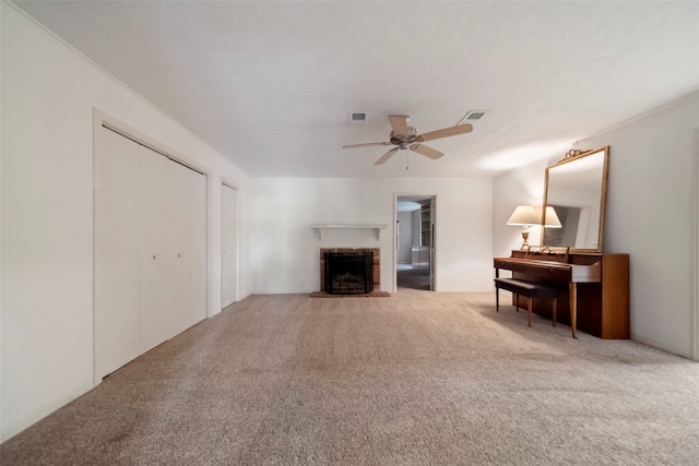 carpeted living room with a brick fireplace and ceiling fan