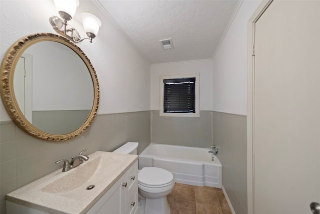 bathroom with tile patterned flooring, toilet, tile walls, vanity, and a textured ceiling