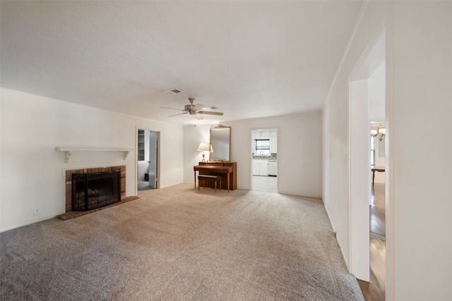 unfurnished living room featuring a fireplace, ceiling fan, and carpet floors