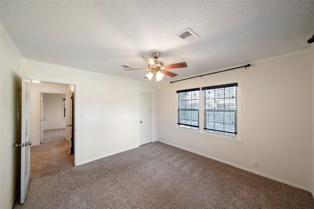 carpeted empty room with ceiling fan, a textured ceiling, and crown molding