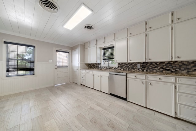 kitchen featuring wood walls, light hardwood / wood-style flooring, sink, dishwasher, and white cabinets