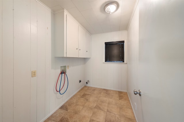 laundry area featuring hookup for a washing machine, cabinets, wood walls, and ornamental molding