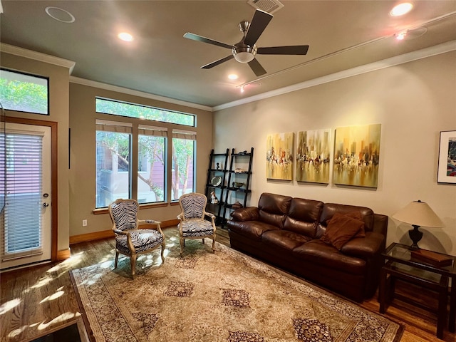 living room with wood-type flooring, ornamental molding, and ceiling fan