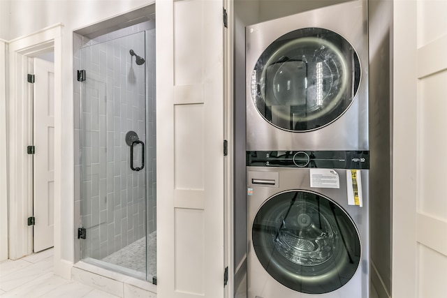 bathroom featuring stacked washer / drying machine and an enclosed shower