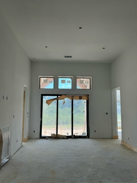 carpeted empty room with a towering ceiling