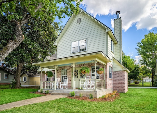 view of front of house featuring covered porch and a front lawn