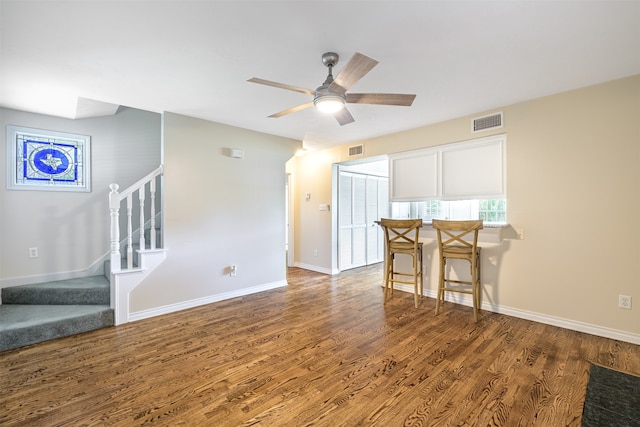 living room featuring dark hardwood / wood-style flooring and ceiling fan