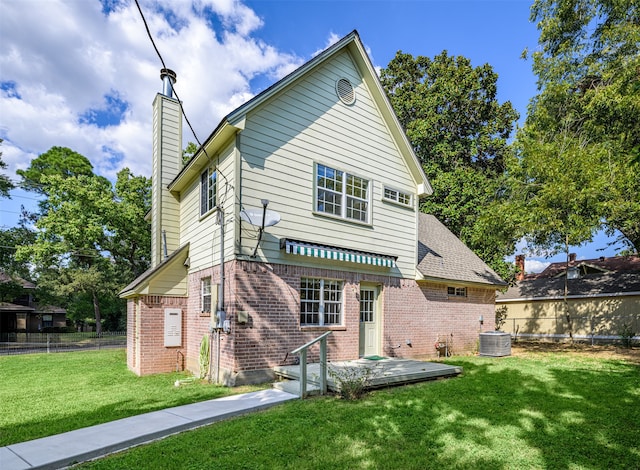 back of house featuring a lawn and central air condition unit