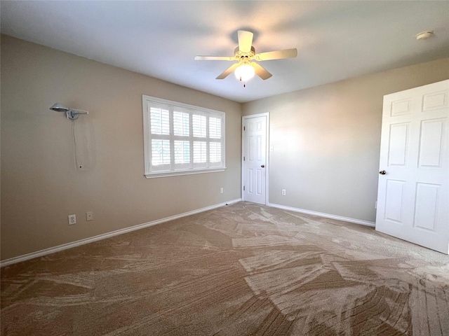 carpeted spare room featuring ceiling fan