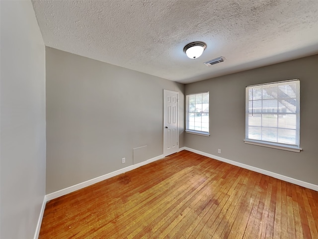 empty room featuring hardwood / wood-style floors and a textured ceiling