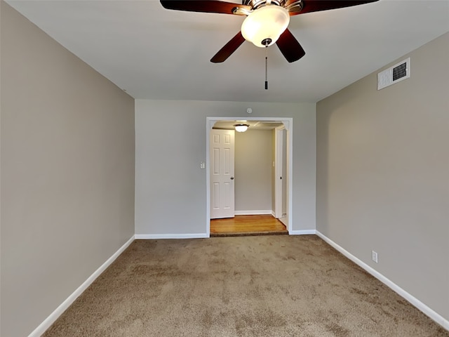 carpeted spare room featuring ceiling fan