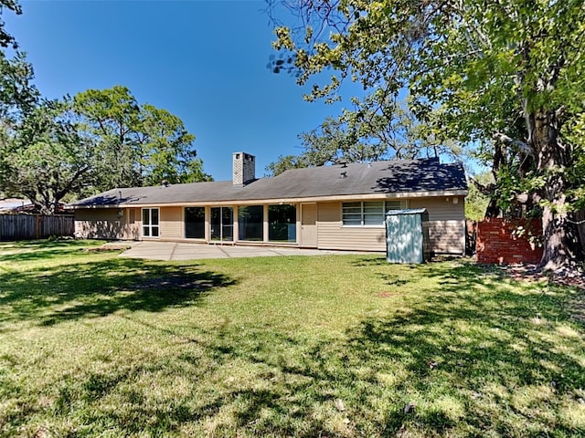 back of property with a yard and a patio area