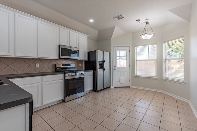 kitchen with white cabinets, decorative light fixtures, backsplash, and appliances with stainless steel finishes