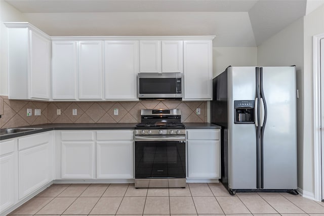 kitchen featuring tasteful backsplash, white cabinetry, and appliances with stainless steel finishes